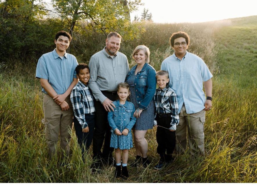 Kristina Siewert with her family in a field at sunset